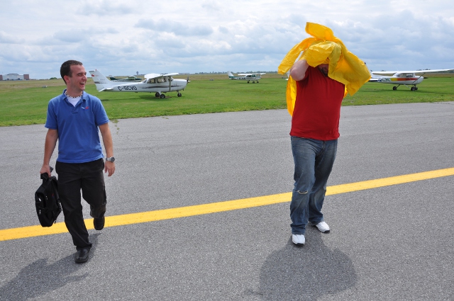 The Rain Coat: Joe was talking about various ways to avoid the soaking.  I offered other alternatives, but he eventually said "Bring it on".  A smart guy, he had another plan and pulled out a rain coat as he walked back from the plane while his instructor, Cory Raby, looked on.