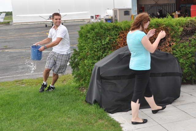 About to get wet.: Kevin Landry runs around the hedge with a bucket to celebrate Hannah's solo.